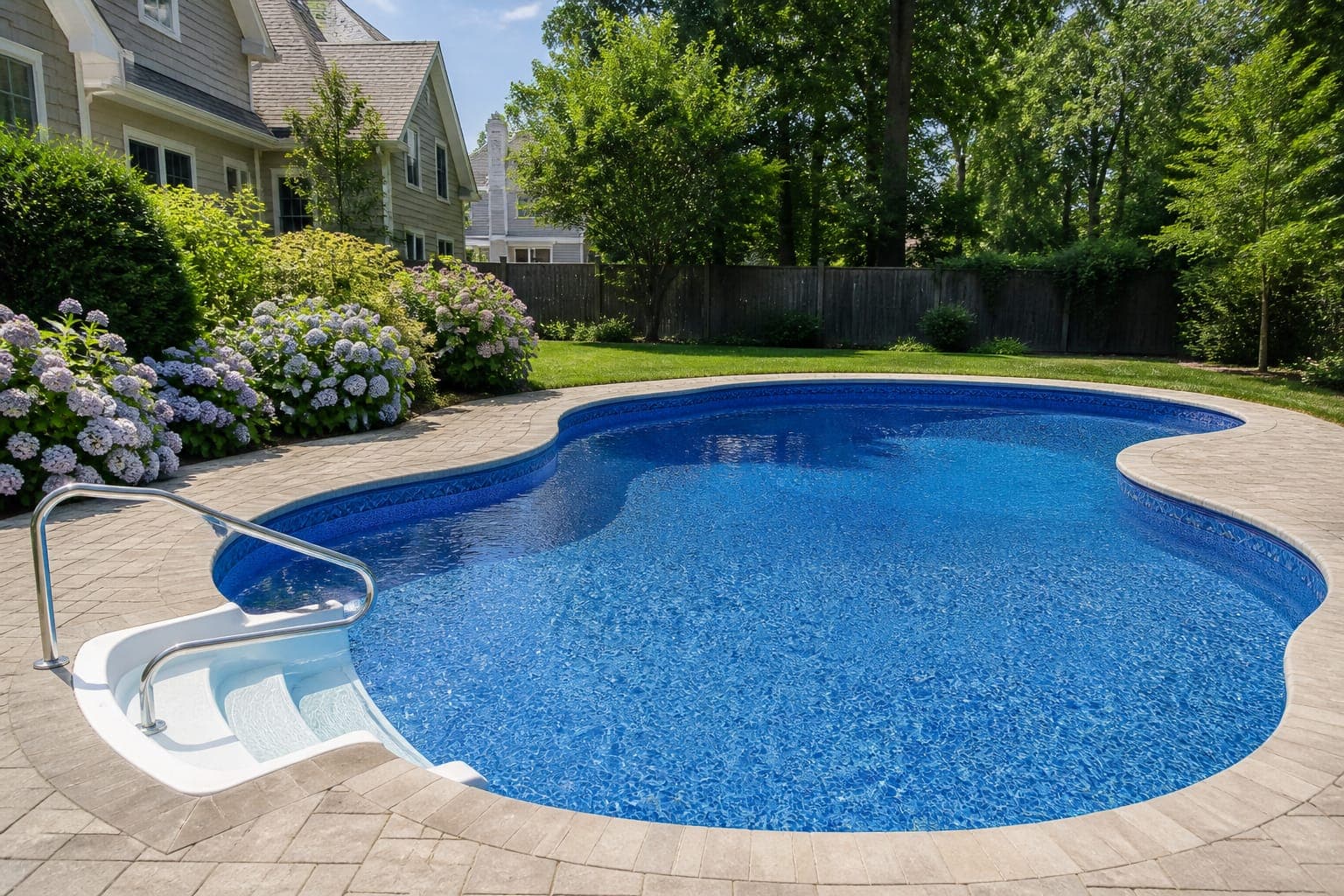 Renovated residential vinyl-liner pool with paver patio and hydrangeas
